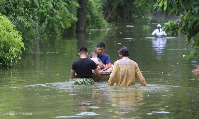 Hundreds gather to reinforce embankments as heavy rains flood Hanoi outskirts